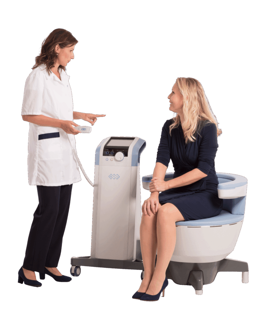 A woman sitting fully clothed on the Emsella chair while a practitioner sets up her treatment